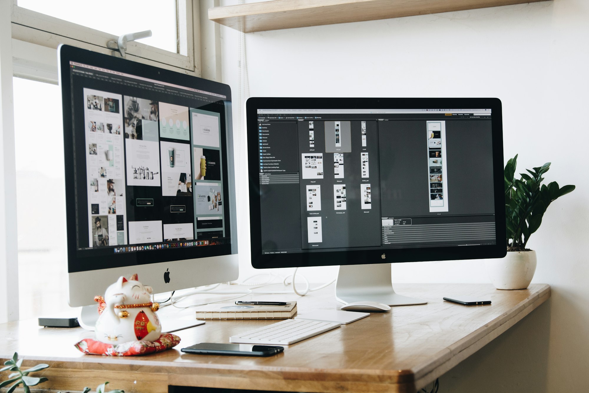 A bright studio desk with two monitors showing app design work