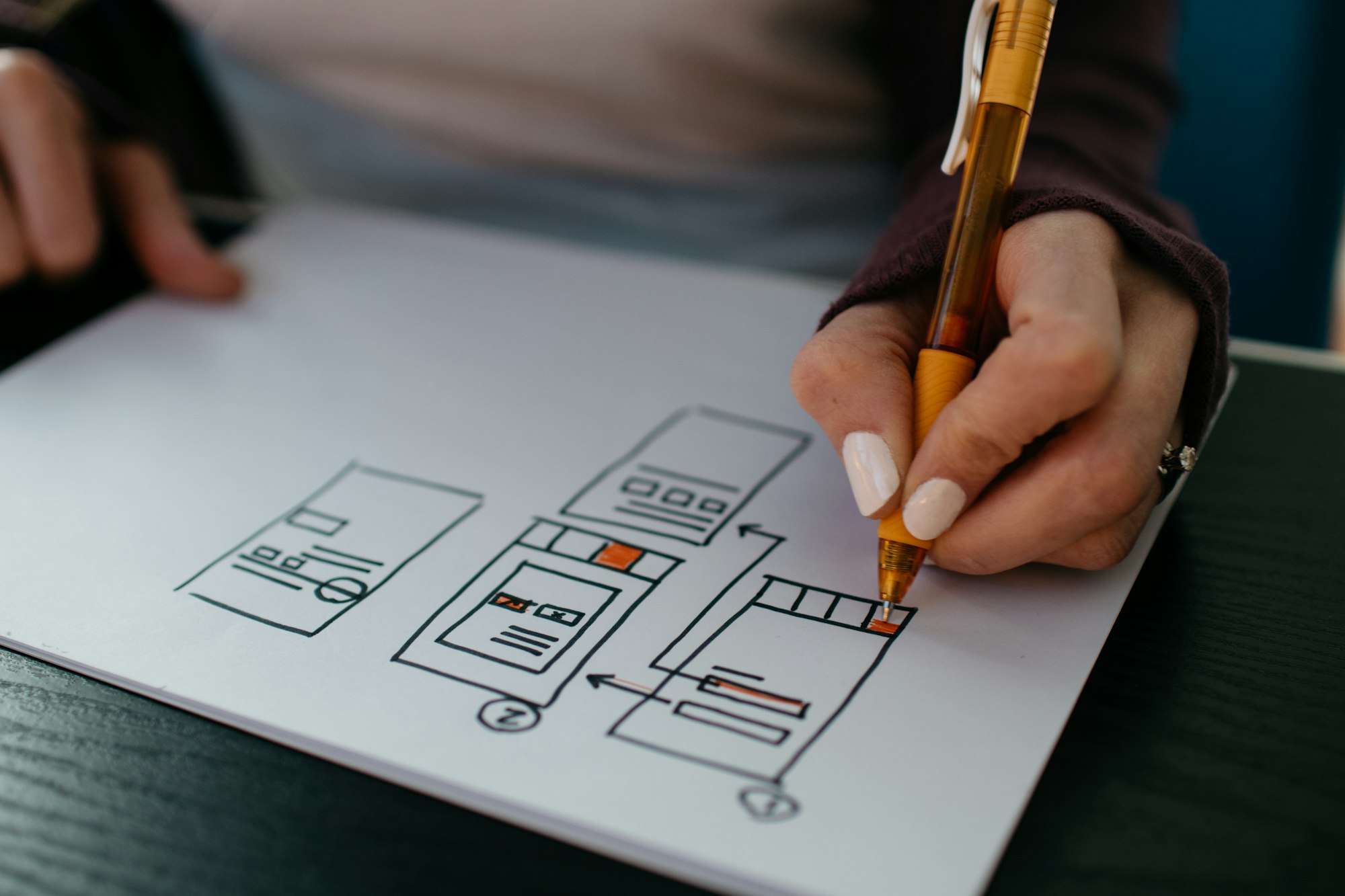 A designer sketching app screens with a pen