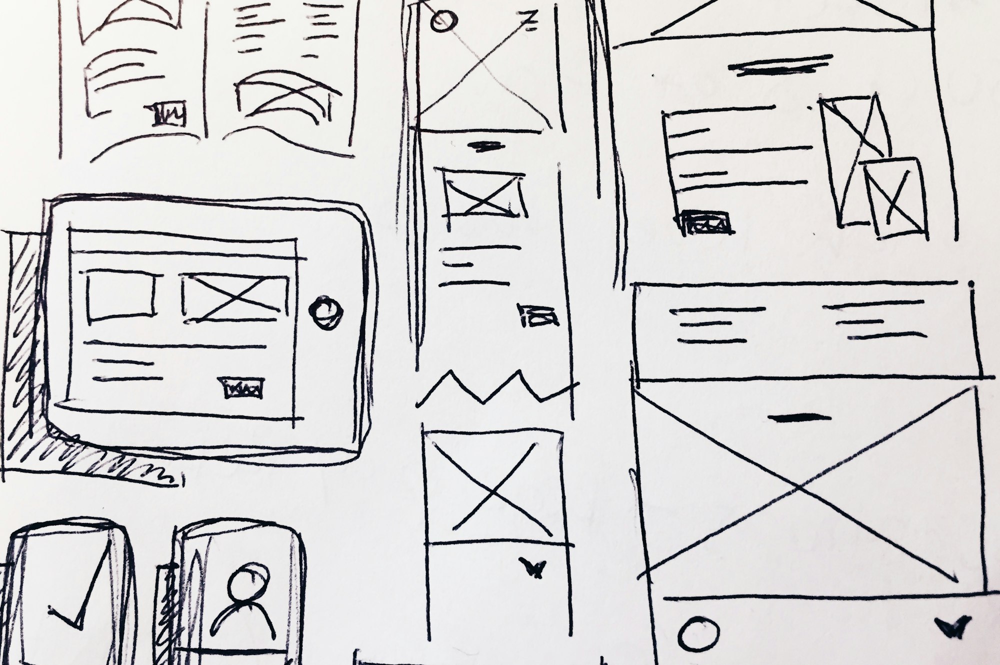 Hand-drawn app wireframes on paper